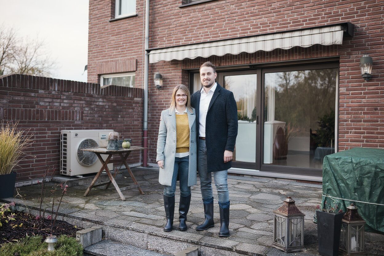 Nederlands stel van middelbare leeftijd in de tuin met een warmtepomp